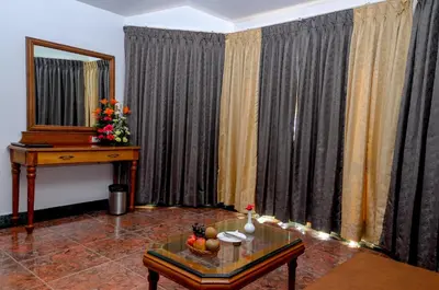 a living room with curtains and a table and a mirror at La Montana by TGI in Ooty