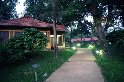 a house with a pathway next to a house with lights at Agraharam Resorts in Thirunelli