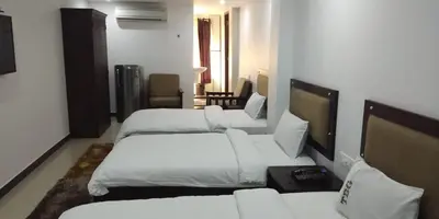 a hotel room with three beds and a room with at ALSHIFA TBG RESIDENCY in Perintalmanna