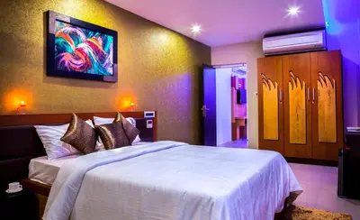 a bedroom with a bed and a painting on the wall at ALSHIFA TBG RESIDENCY in Perintalmanna