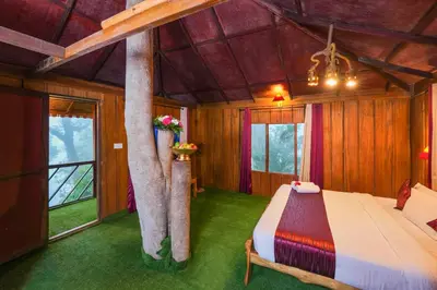 a bedroom with a bed and a tree at Nature Zone Jungle Resort- Experience the Wilderness & Adventure in Munnar