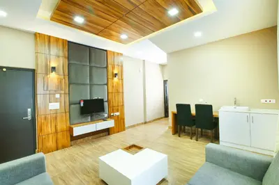 a room with a table and chairs and a tv at MAZUS INN in Vythiri