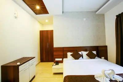a hotel room with a bed and a desk at MAZUS INN in Vythiri