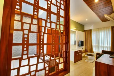 a room with a large wooden door with a living room at MAZUS INN in Vythiri