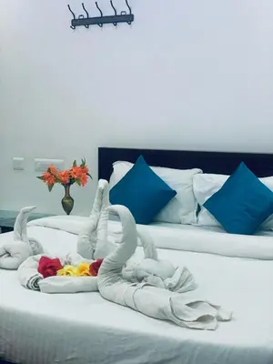 a bed with two swans made out of towels at Deluxe Residency in Kalpetta
