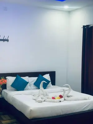 a bedroom with a bed with towels on it at Deluxe Residency in Kalpetta