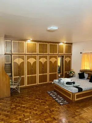 a bedroom with a bed in a room with wooden cabinets at Chill Inn - Families Only in Ooty