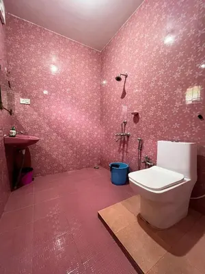 a pink bathroom with a toilet and a sink at Chill Inn - Families Only in Ooty
