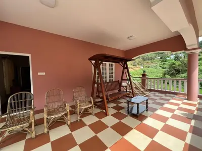 a porch with chairs and a swing at Chill Inn - Families Only in Ooty