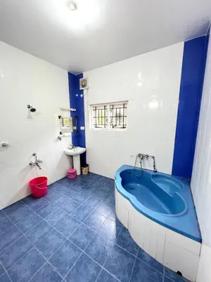 a bathroom with a blue tub and a sink at Chill Inn - Families Only in Ooty