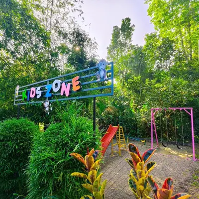 a playground with a sign and a swing set at Le Eden Premium Wayanad Pool Resort in Sultan Bathery