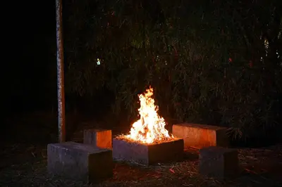 a fire pit at night with stones around it at Le Eden Premium Wayanad Pool Resort in Sultan Bathery