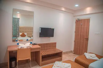 a small room with a desk and a television on the wall at Park Avenue Suites in Coimbatore