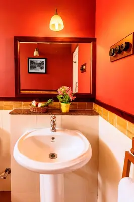 a bathroom with a white sink and a mirror at Teanest by Nature Resorts and Stays in Coonoor