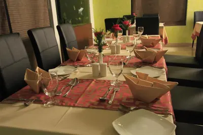 a table with plates and wine glasses on it at Park Residency Airport Road in Kozhikode