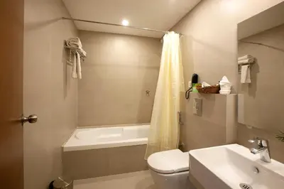 a bathroom with a toilet and a tub and a sink at Park Residency Airport Road in Kozhikode