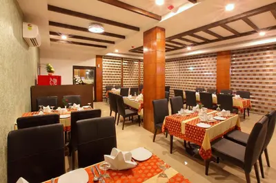 a restaurant with tables and chairs in a room at Park Residency Airport Road in Kozhikode