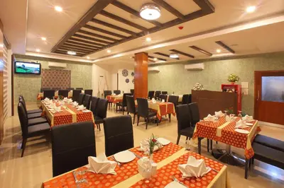 a banquet hall with tables and chairs in a room at Park Residency Airport Road in Kozhikode