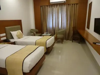 a hotel room with two beds and a table at Park Residency Airport Road in Kozhikode