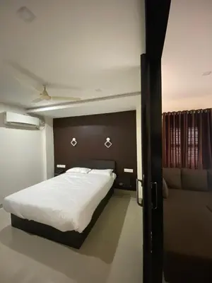 a bedroom with a large bed and a couch at Town Hub in Valāncheri