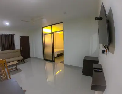 a living room with a couch and a television at Town Hub in Valāncheri