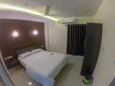 a bedroom with a bed and a ceiling fan at Town Hub in Valāncheri