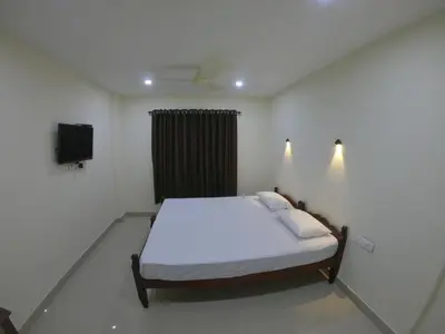 a bedroom with a bed and a television in it at Town Hub in Valāncheri