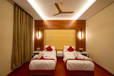 a hotel room with three beds and a ceiling at JK HOTELS in Coimbatore