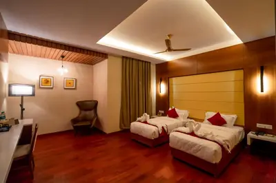 a hotel room with two beds and a desk at JK HOTELS in Coimbatore