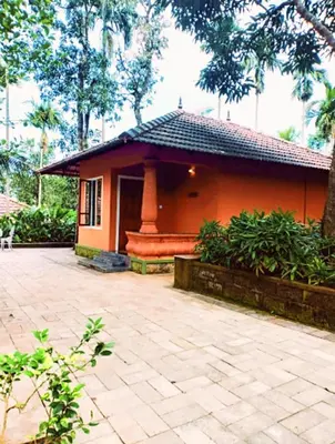 a small house with a patio in front of it at Indeevara Luxury Resort and Spa, Wayanad in Vythiri