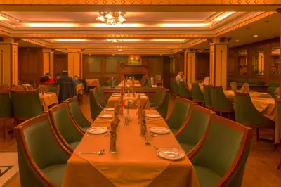 a dining room with a long table and chairs at Hotel Nahar Nilgiris in Ooty