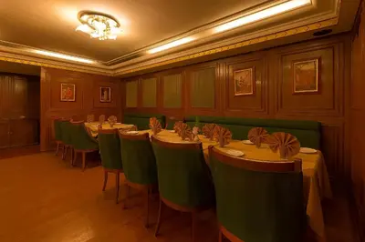 a conference room with tables and green chairs at Hotel Nahar Nilgiris in Ooty
