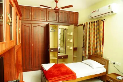 a bedroom with a bed and a ceiling fan at ZuriEL Suite GUEST HOUSE in Coimbatore