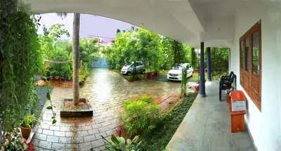an outside view of a courtyard with cars parked at Monsoon Apartments in Kannur