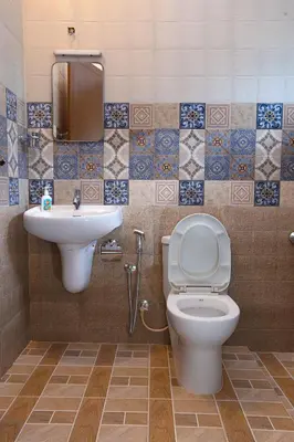 a bathroom with a toilet and a sink at Monsoon Apartments in Kannur