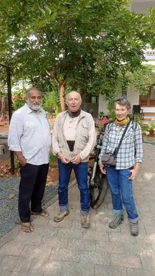 a group of three men standing next to a motorcycle at Monsoon Apartments in Kannur