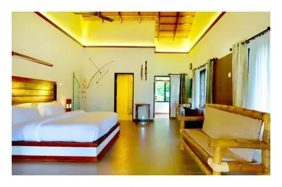 a bedroom with a bed and a couch in it at Vayal Veedu in Muthanga