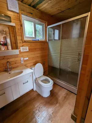 a bathroom with a toilet and a shower and a sink at The Door to Nirvana Backpackers Hostel Kotagiri in Kotagiri