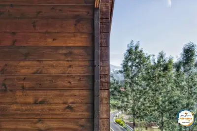a wooden door of a building with trees in the background at The Door to Nirvana Backpackers Hostel Kotagiri in Kotagiri