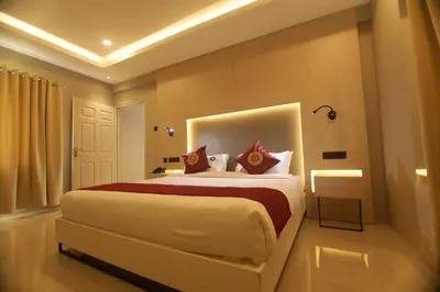 a bedroom with a large white bed with red pillows at Noor jehan's Grand Noor in Palakkad