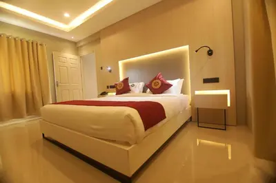 a bedroom with a large white bed with red pillows at Noor jehan's Grand Noor in Palakkad