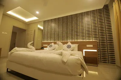 a bedroom with a large white bed with swans on it at Noor jehan's Grand Noor in Palakkad