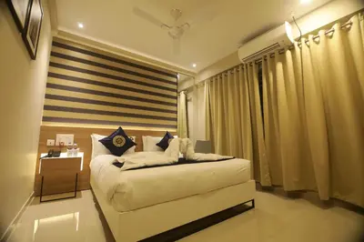 a bedroom with a large white bed and a window at Noor jehan's Grand Noor in Palakkad