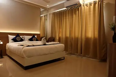 a bedroom with a bed and a window with curtains at Noor jehan's Grand Noor in Palakkad