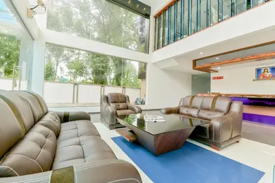 a living room with a couch and a table at Super Townhouse Edassery Blue Bells in Cochin