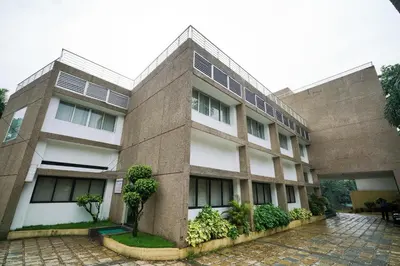 a large brick building with trees in front of it at Townhouse Mookkannoor Tourist Home in Cochin
