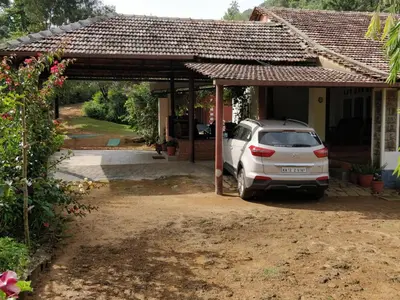 a car parked in front of a house at Kabbe Holidays in Madikeri