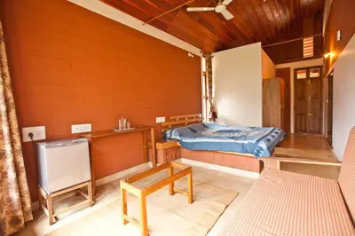 a room with a bed and a table in it at Kabbe Holidays in Madikeri