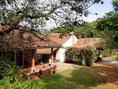 a house with a garden and flowers in the yard at Kabbe Holidays in Madikeri