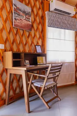 a desk and a chair in a room with a window at Machaan Wilderness Lodge Nagarahole in Srimangala